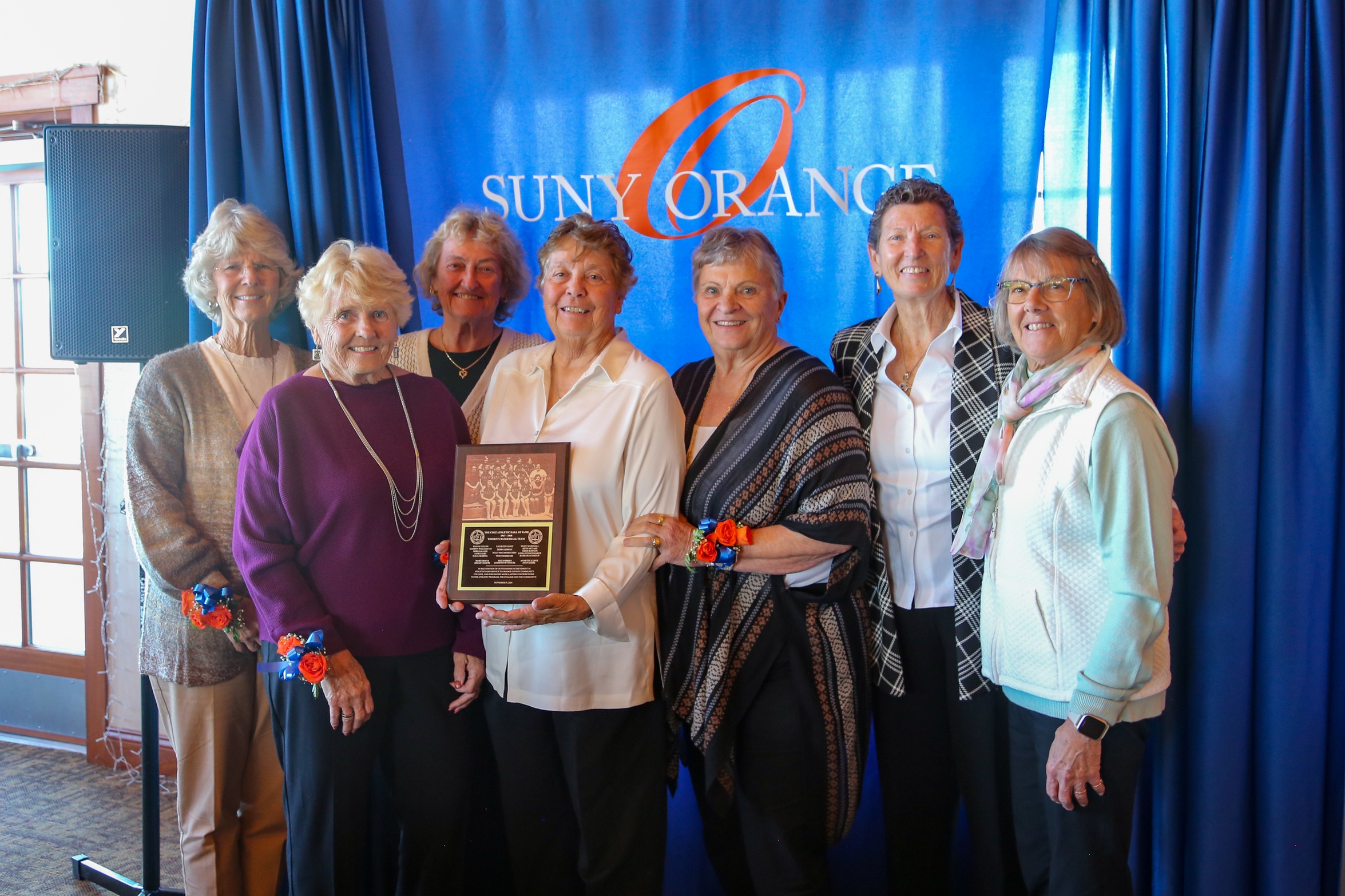 Eight members of the 1967-98 team holding their award during the Hall of Fame ceremony in November 2024